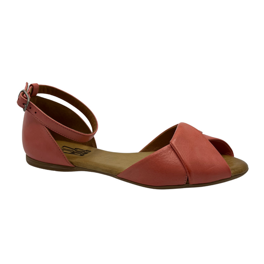 45 degree angled view of pink leather ballet flat sandal with buckle ankle strap and peep toe.