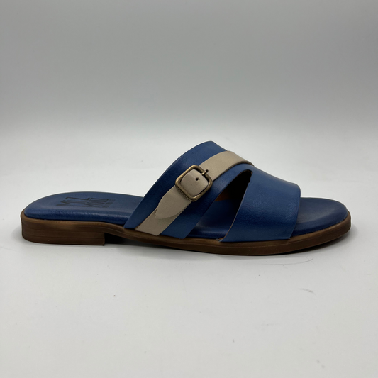 Right facing view of denim blue leather slip on sandal with a cushioned, leather lined insole and a decorative cream coloured buckle strap.