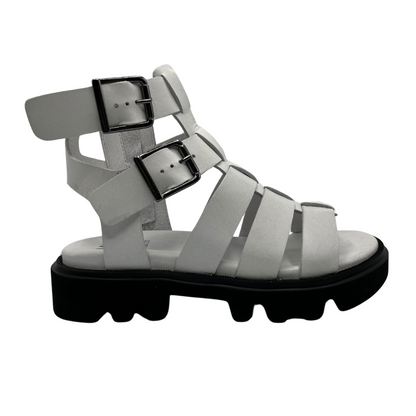 Right facing view of white leather gladiator sandal with black rubber outsole. Lined footbed and double buckle straps
