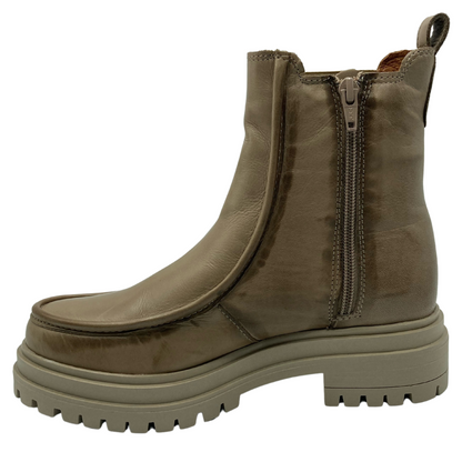 Left facing view of beige leather short boot with zipper closure, chunky, rubber, outsole and pull on tab