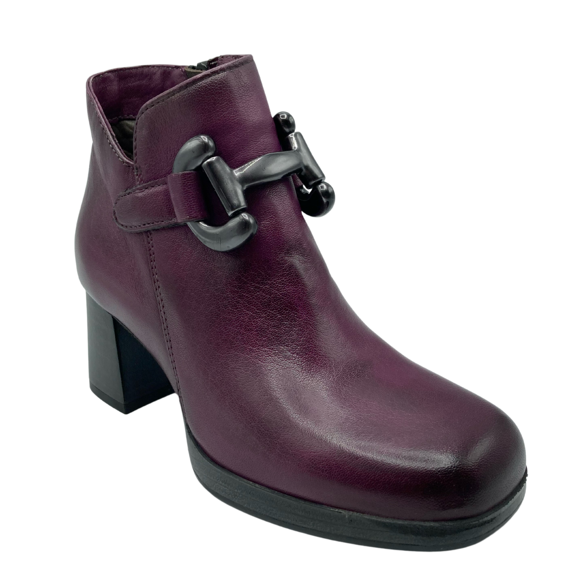 Angled view of purple leather ankle boot with bit detail