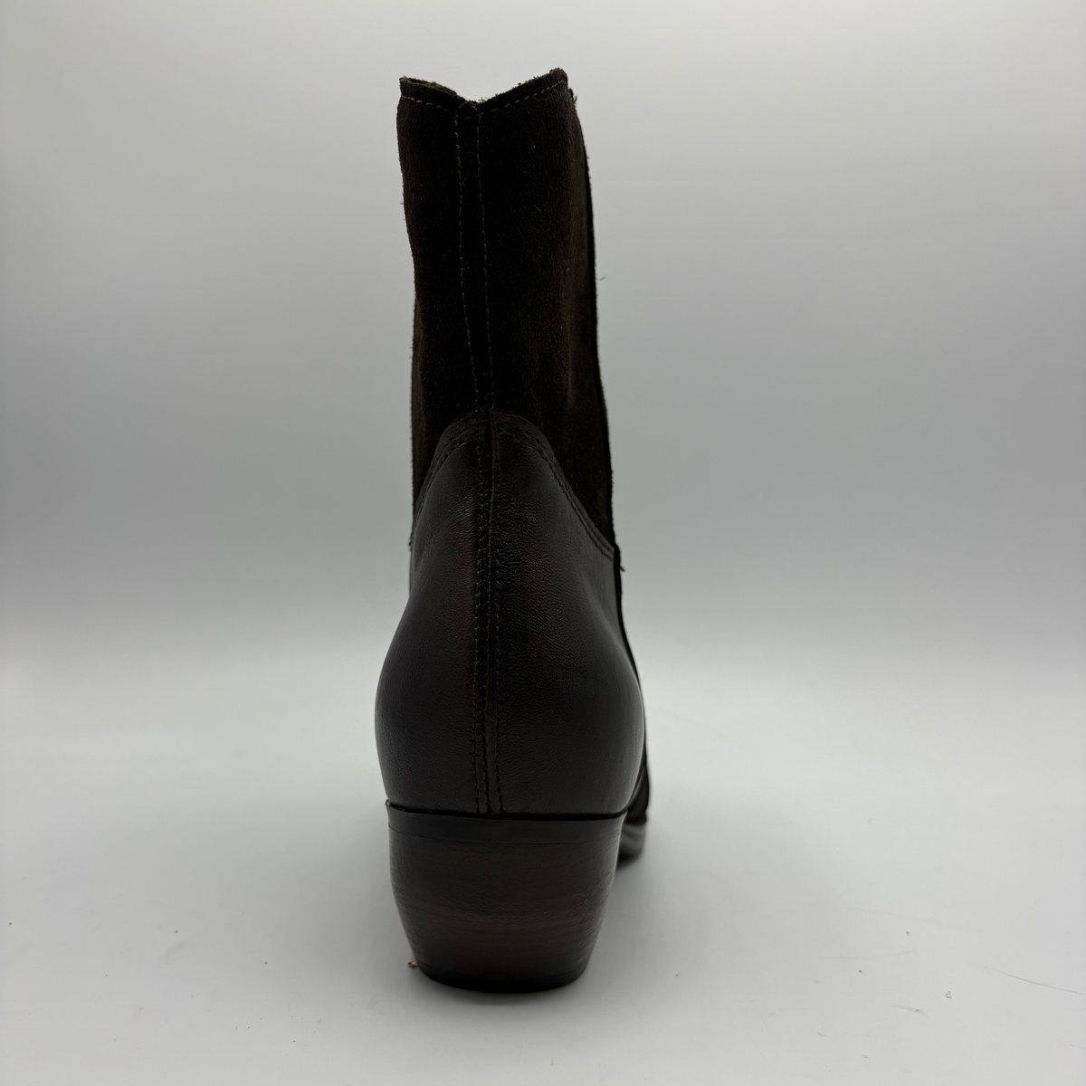 A single dark brown leather ankle boot shown from the back on a light gray studio background.