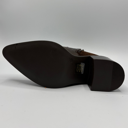 The sole of a dark brown leather boot, showing a pointed toe and a textured black rubber outsole
