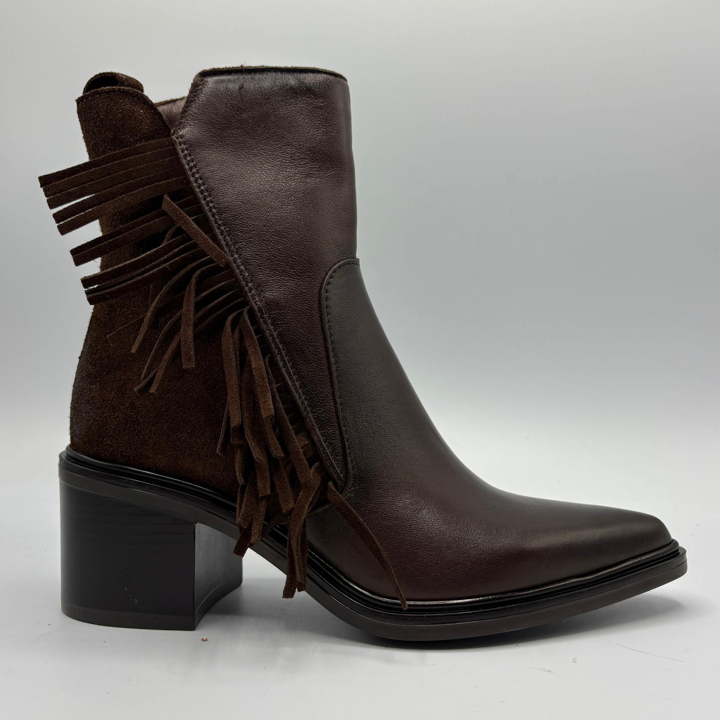 Black ankle boot with a fringe accent on a white background