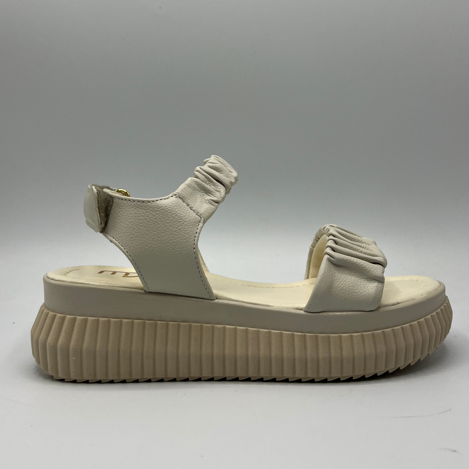 Right facing view of an ivory coloured leather sandal with a thick platform outsole and an adjustable sling back strap.