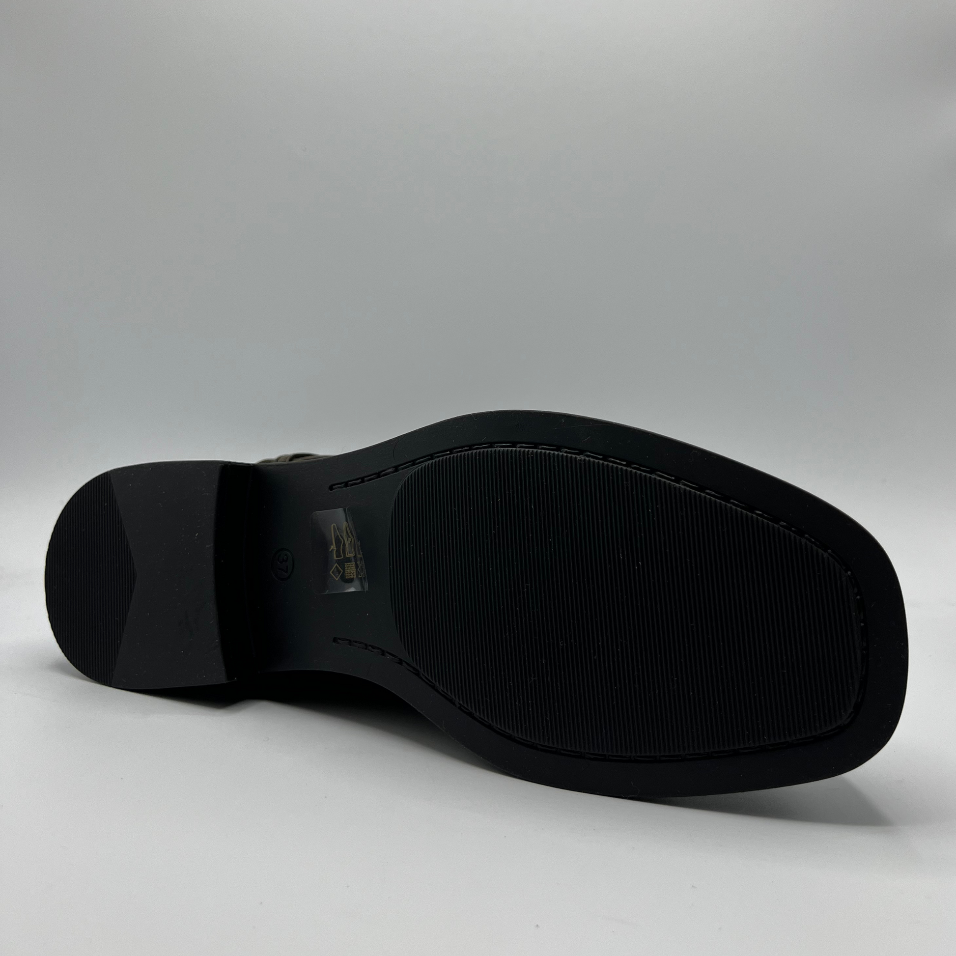 Black boot sole on a gray background