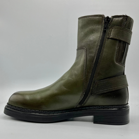 Green leather boot with a black sole on a white background