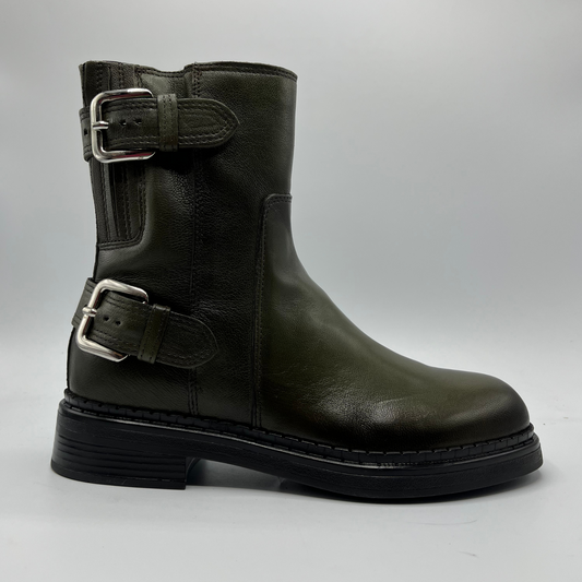Green leather boot with buckles on a gray background