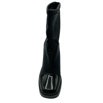 Front view of sleek fitted black boot with patent leather toe