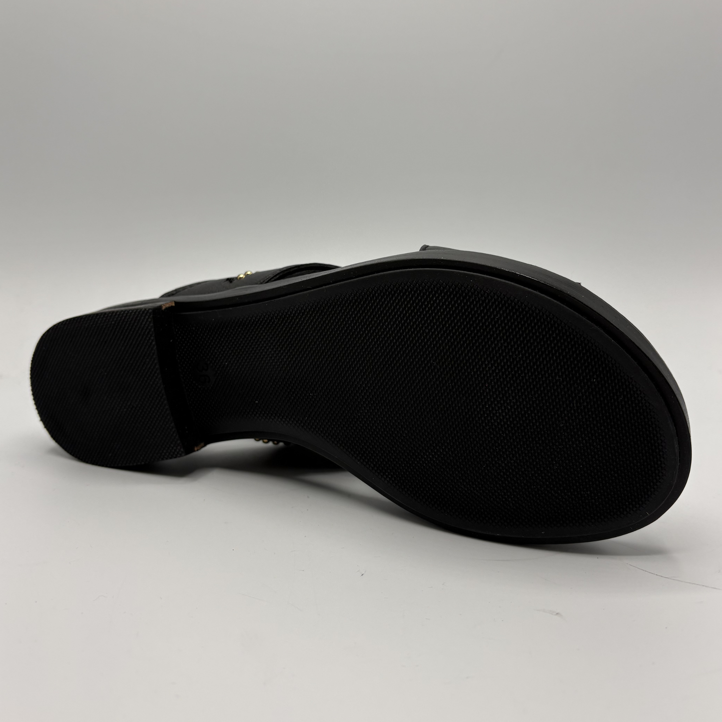 Black sandal sole on a light gray background