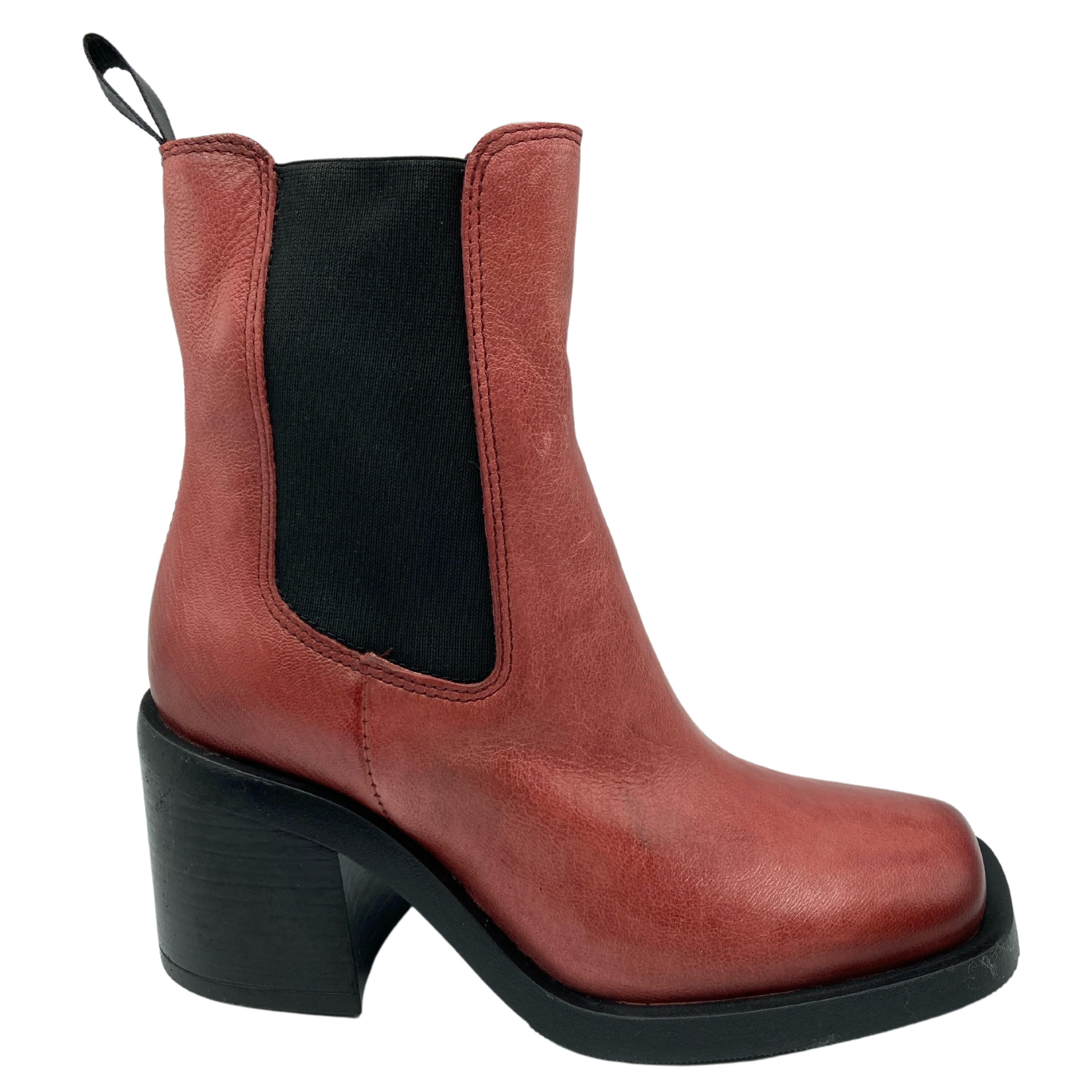 Profile view of mid-calf height red-orange chunky heeled boot