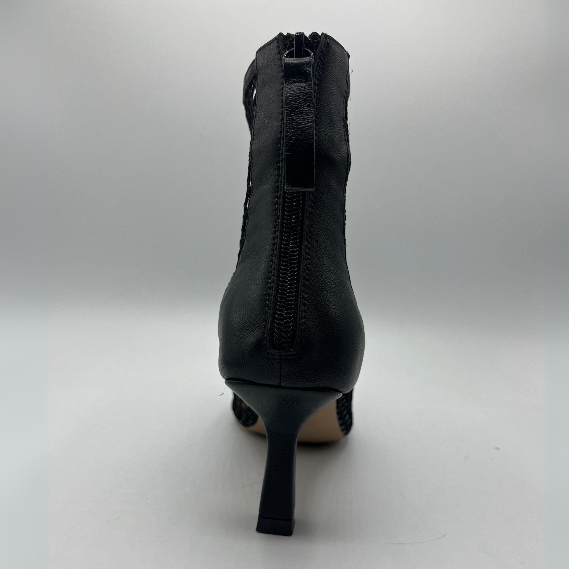 Back view of a black mesh heeled boot