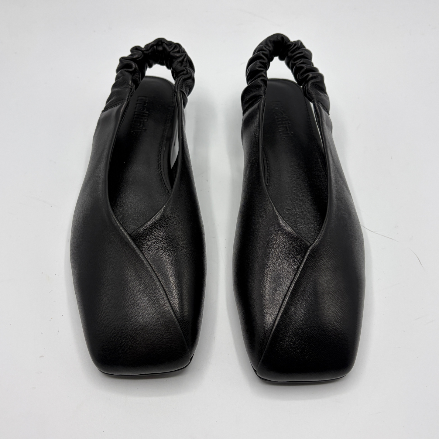 Pair of black leather shoes with a unique design on a white background