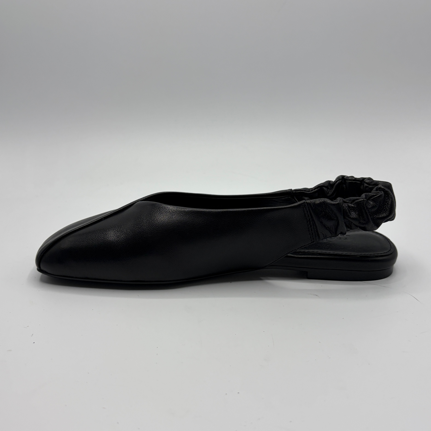 Black flat shoe on a light gray background