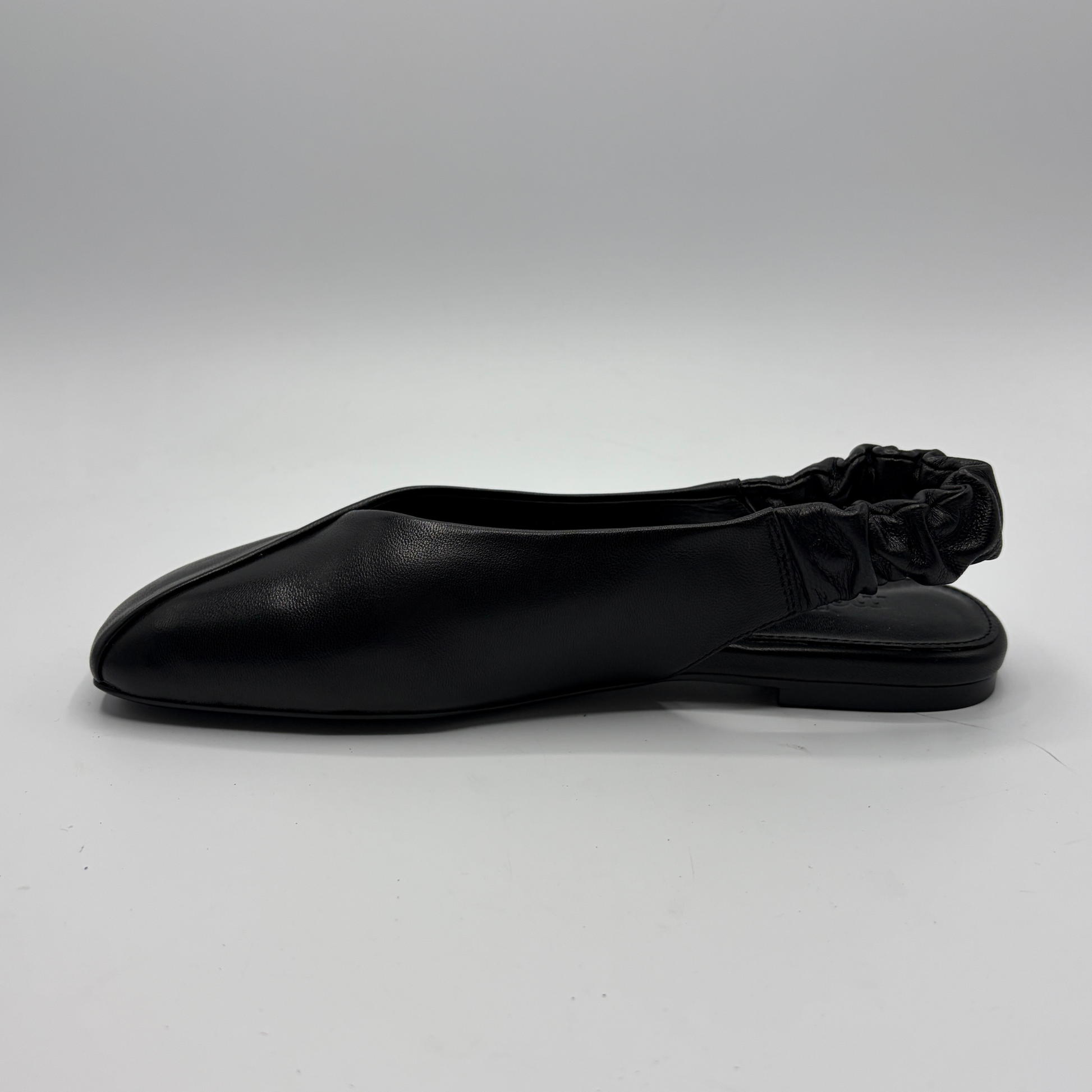 Black flat shoe on a light gray background