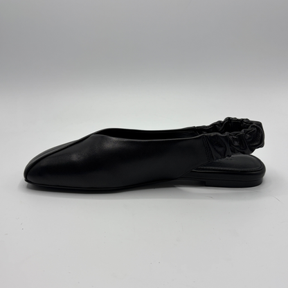 Black flat shoe on a light gray background