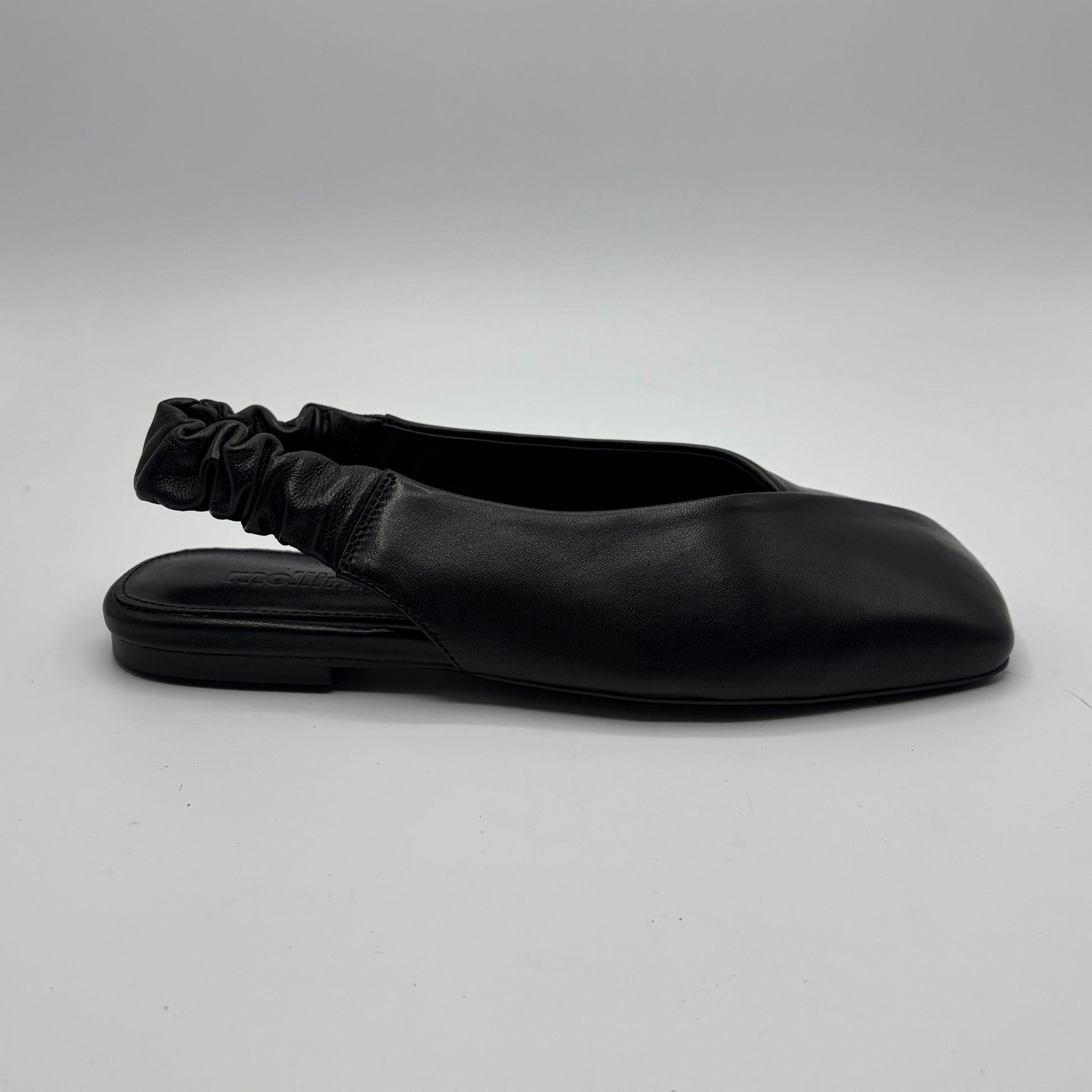 Black flat shoe with a sock-like design on a gray background