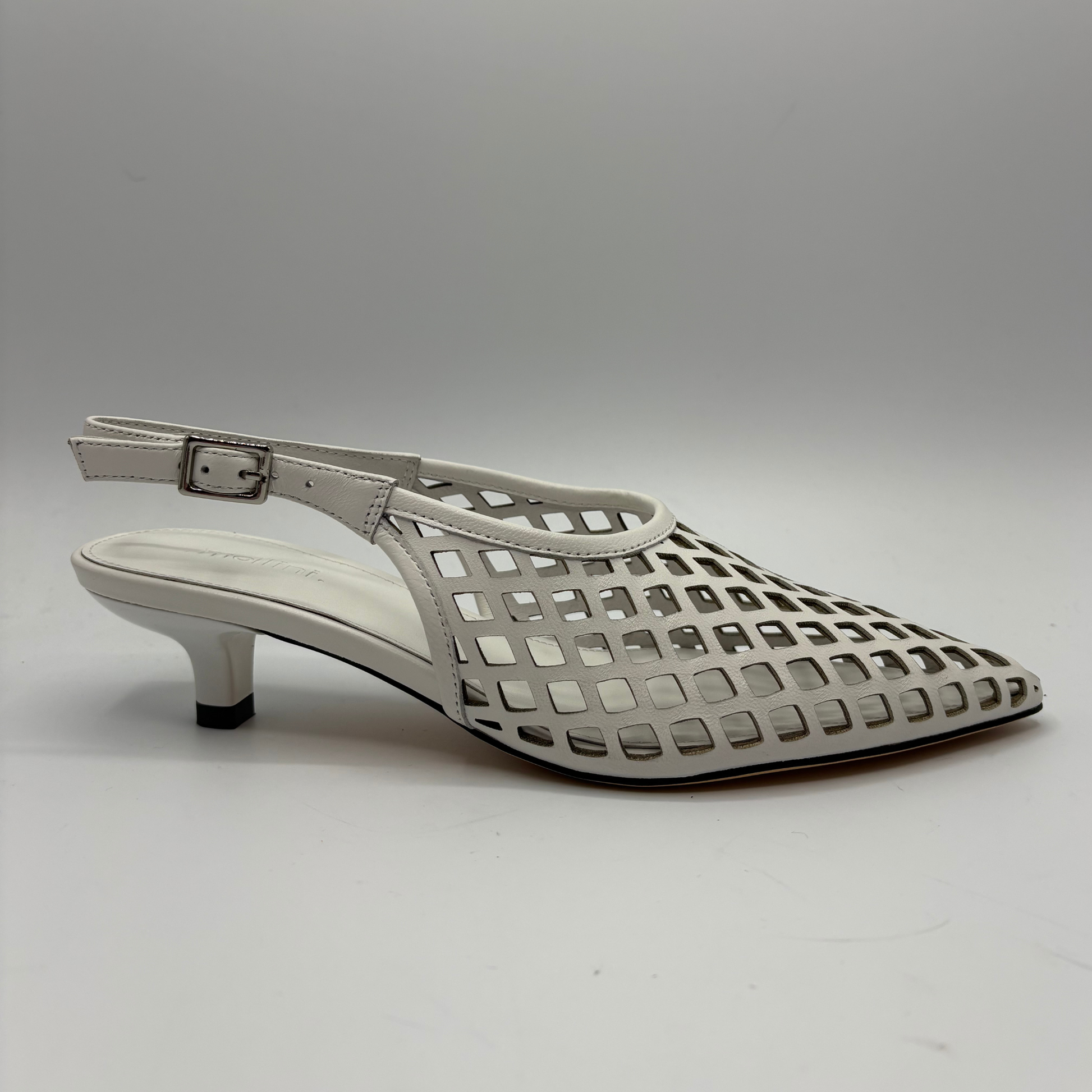 White sandal with openwork design on a gray background
