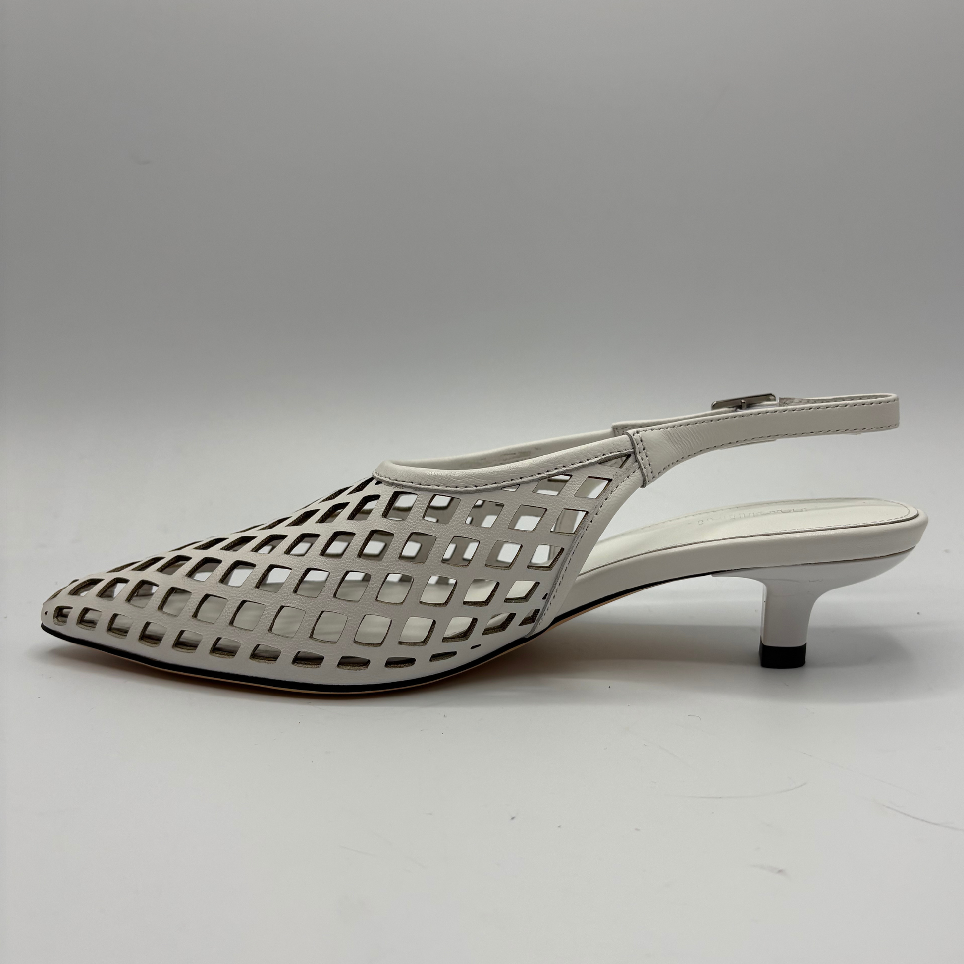 White sandal with perforated design on a gray background