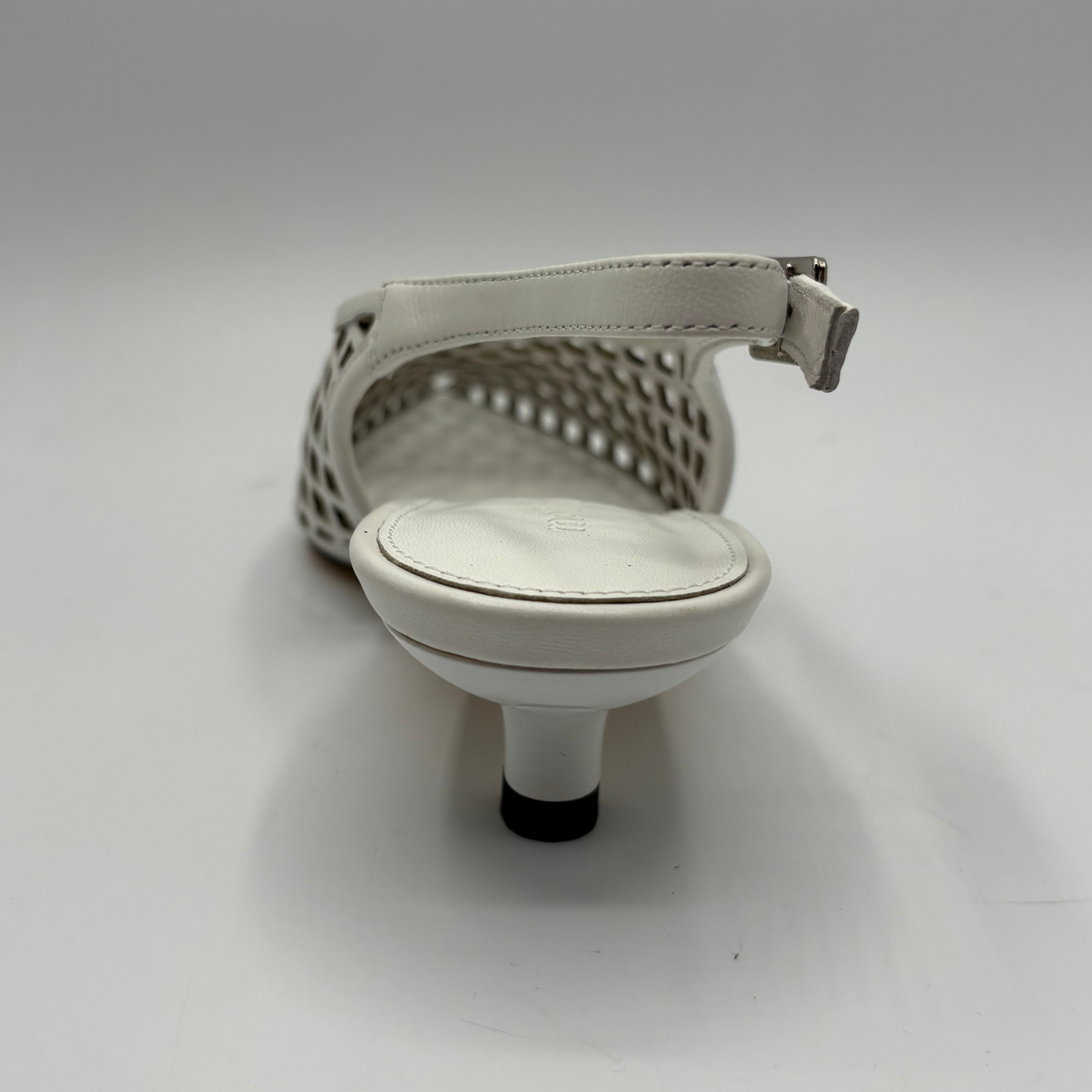 White sandal with a minimalist design on a gray background