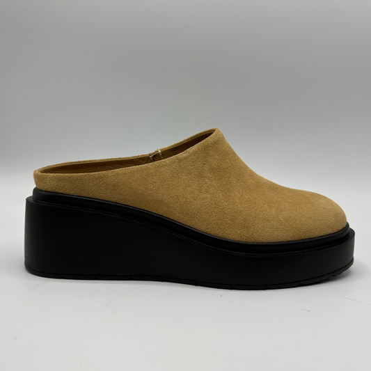 A single slip-on wedge mule shoe in tan suede with a thick black platform sole, shown from a side profile against a neutral gray background.