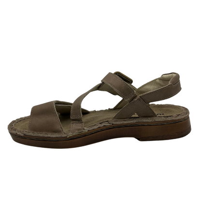 Left facing view of khaki leather sandal with velcro toe strap, padded collar and suede lined footbed