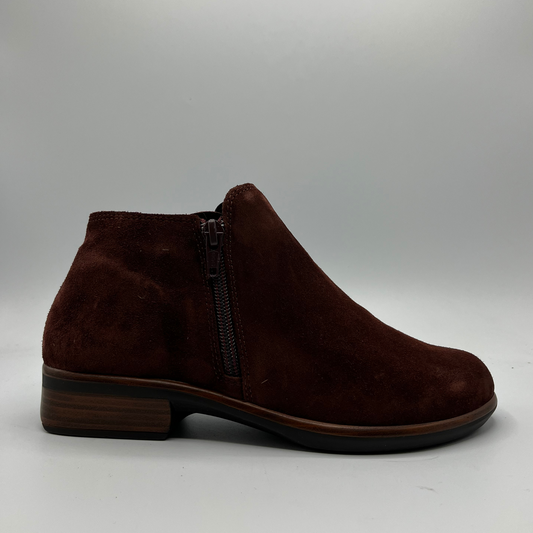 Brown suede ankle boot with a zipper on a gray background
