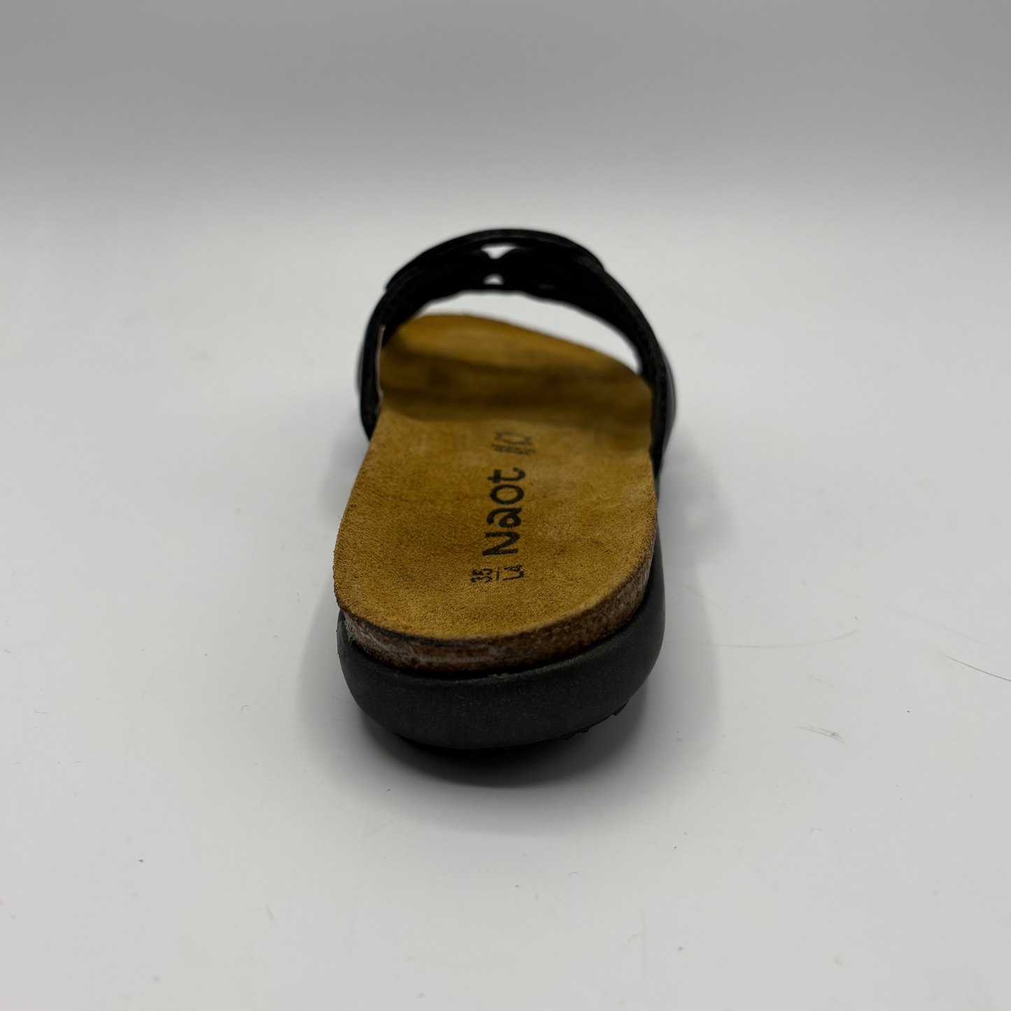 Black sandal with a tan insole on a white background
