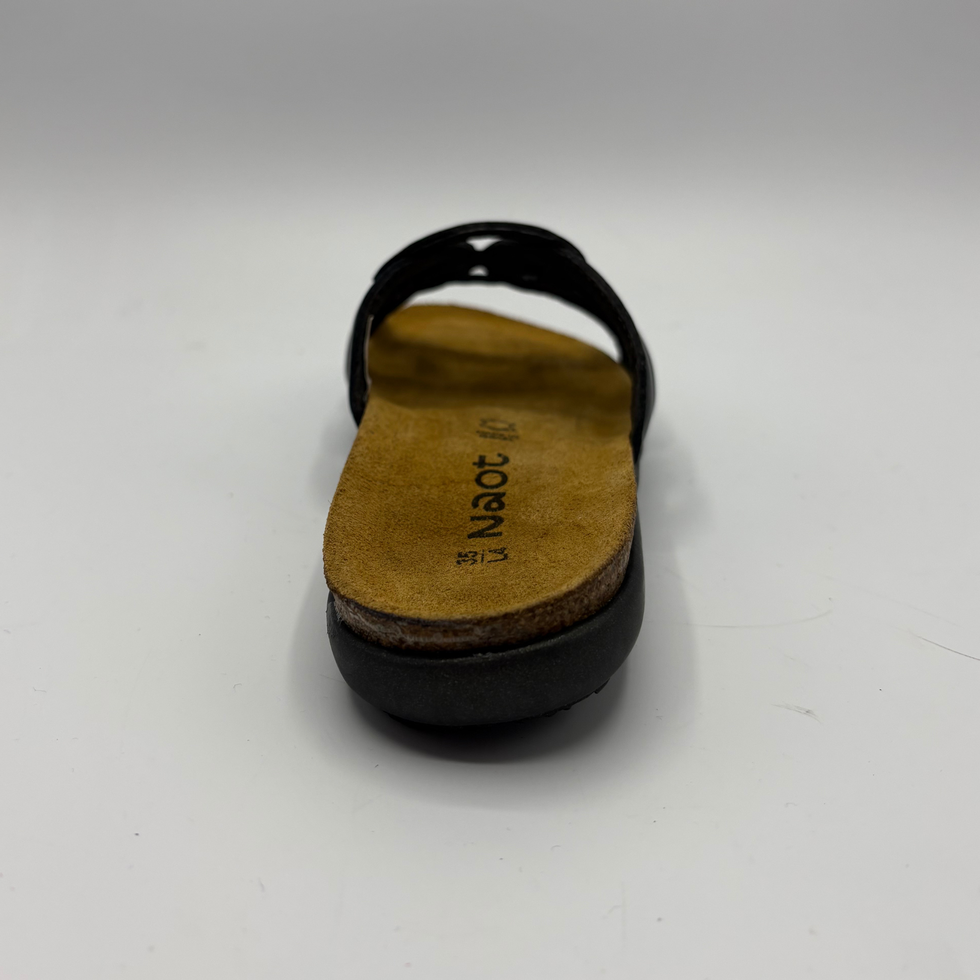 Black sandal with a tan insole on a white background