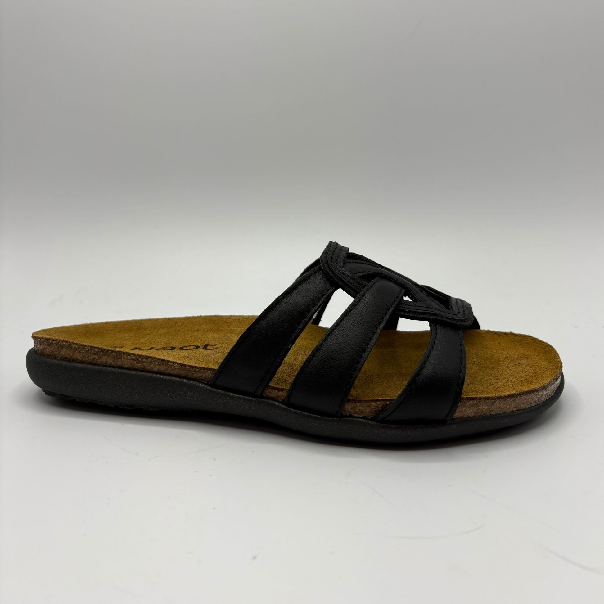 Black sandal with a brown sole on a white background