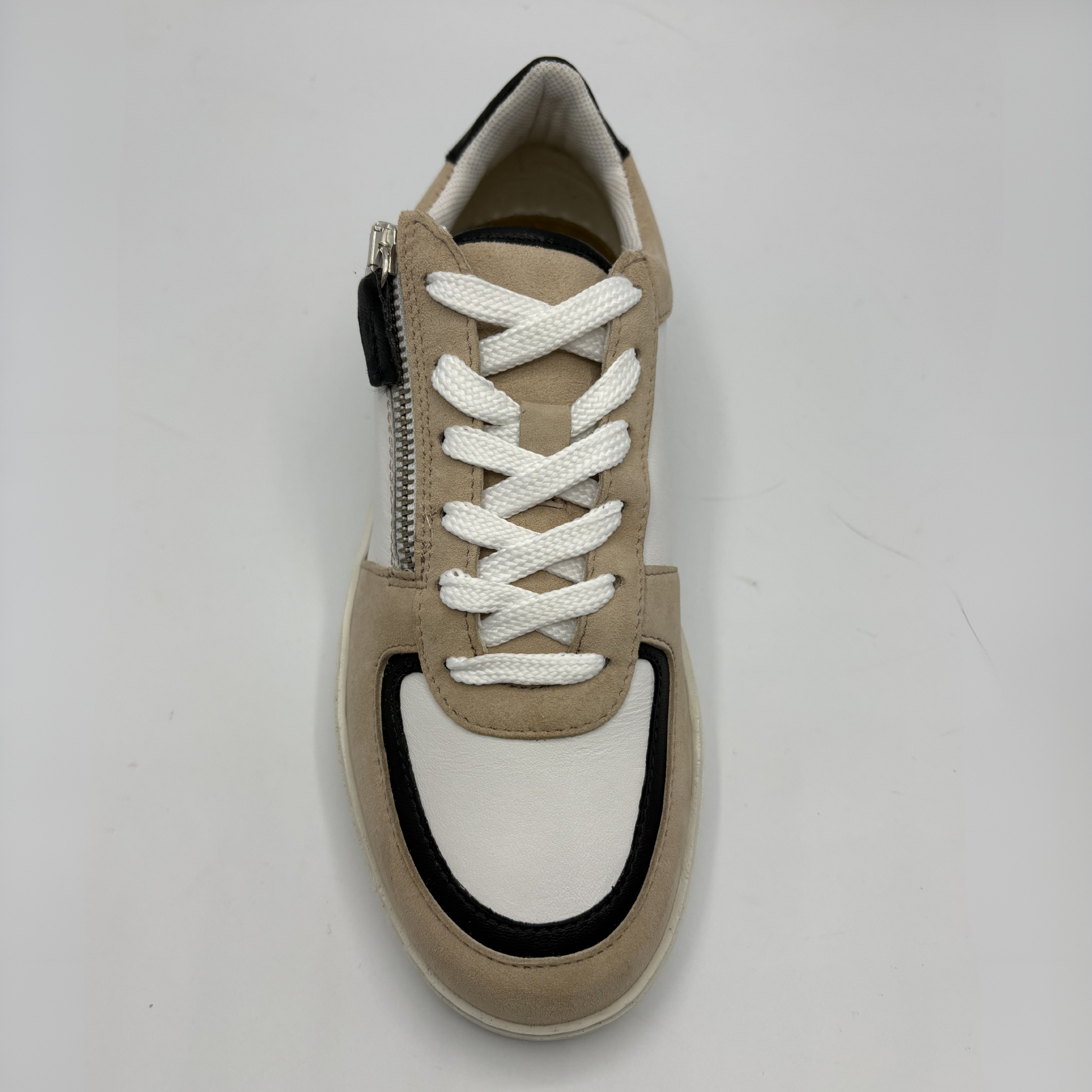 Top view of an almond, black and white sneaker with laces and a side zipper