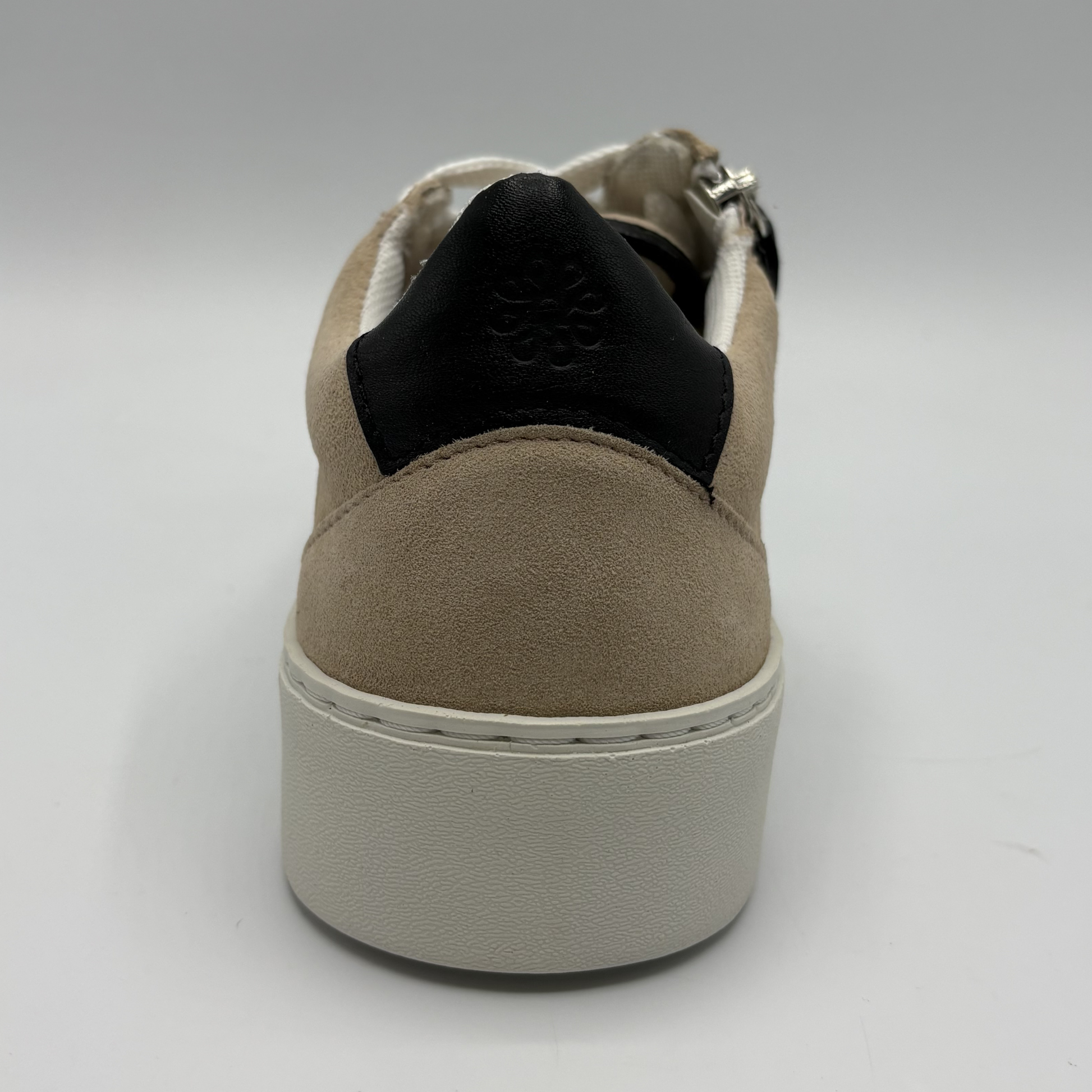 Back view of an almond, black and white sneaker with laces and a side zipper