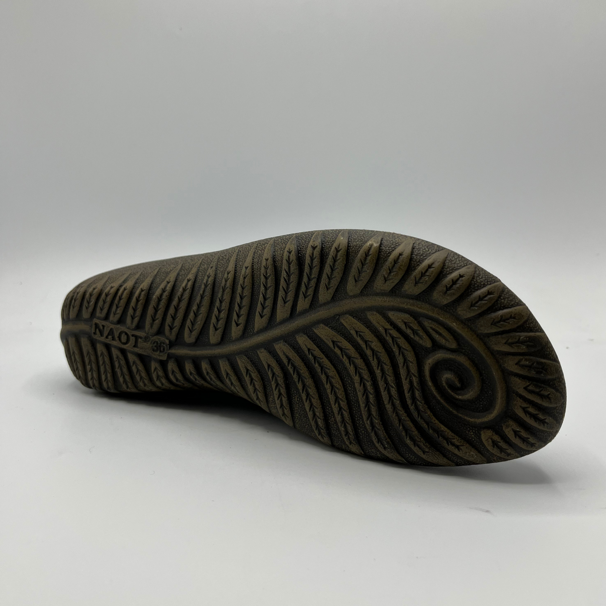 Close-up of a brown sole with tread pattern on a white background