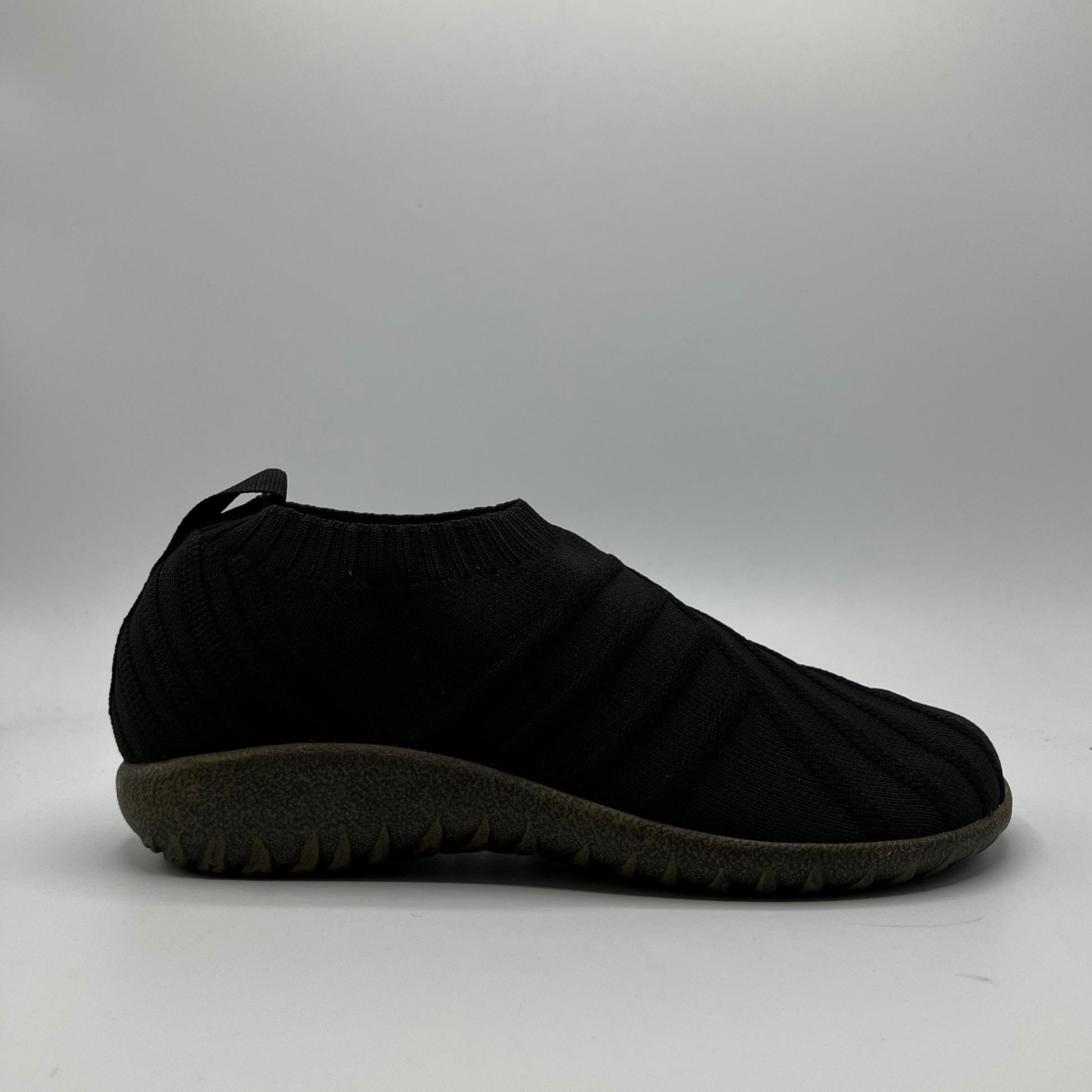 Black slip-on shoe on a gray background