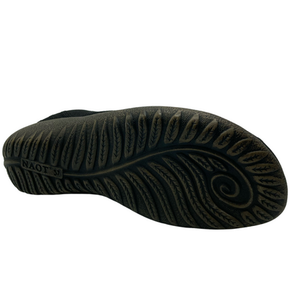 Bottom view of polyurethane sole of black knit shoe with leaf texture design