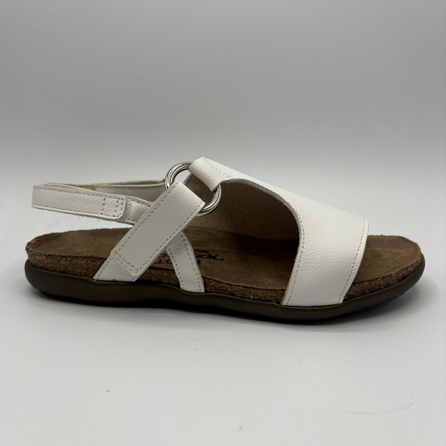 White sandal with a brown sole on a gray background
