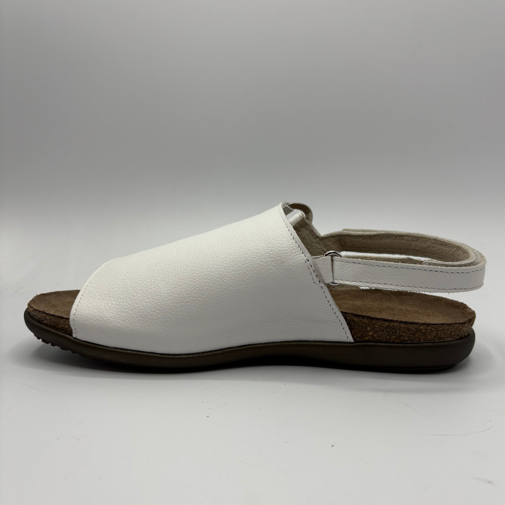 White sandal with brown sole on a gray background