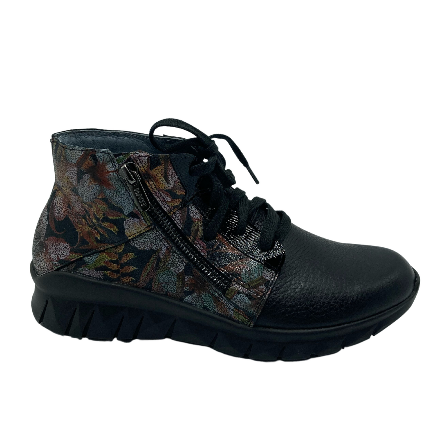 Right facing view of black leather sneaker with floral accent and black slip resistant sole