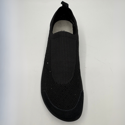 A single black slip-on knit shoe with a textured knit upper and a black sole, photographed from a top-down angle on a light gray background.