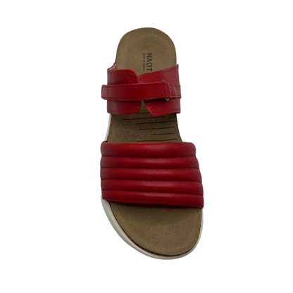 Top view of red leather slip on sandal with white rubber outsole, padded front strap and open toe
