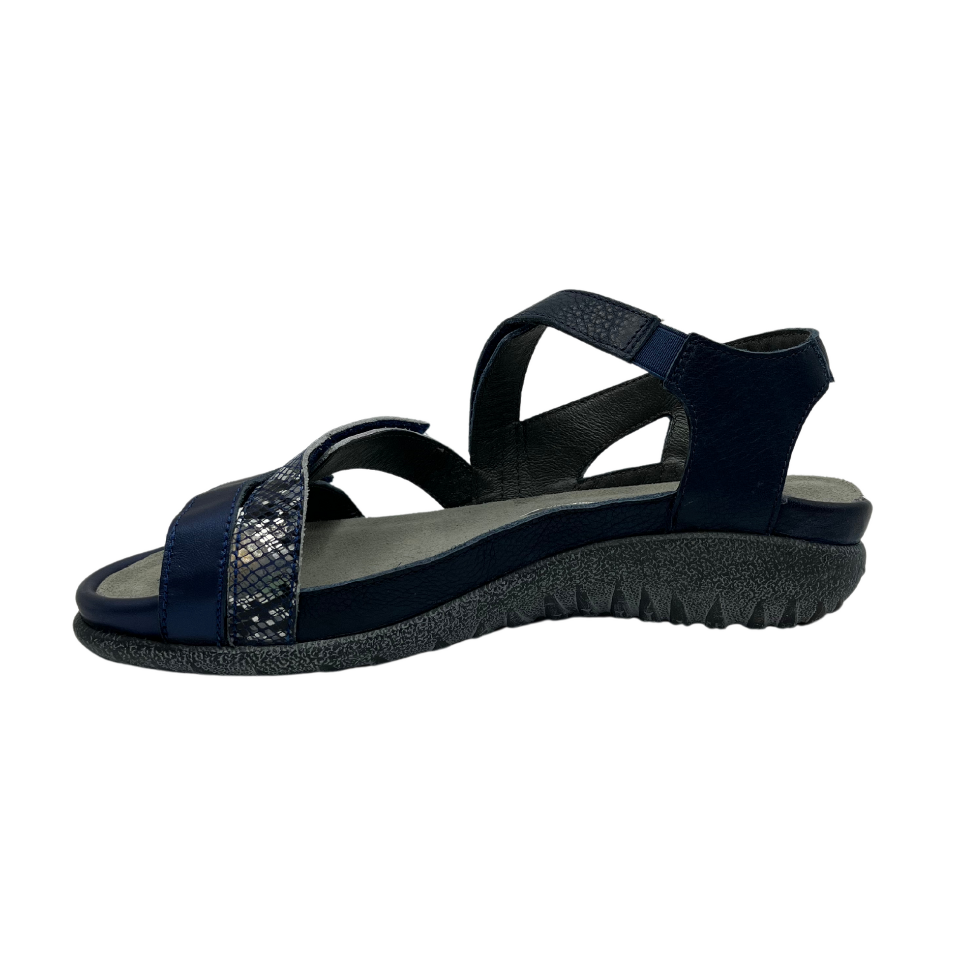 Left facing view of navy leather sandal with 3 velcro straps, wedge sole and metallic detail