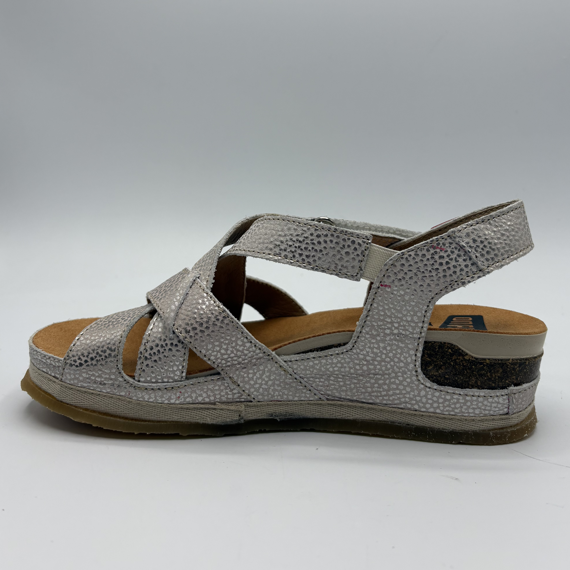Silver sandal with criss-cross straps on a white background