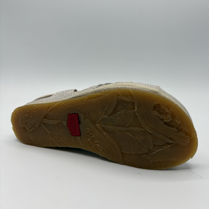 Close-up of a shoe sole with a red label on a white background