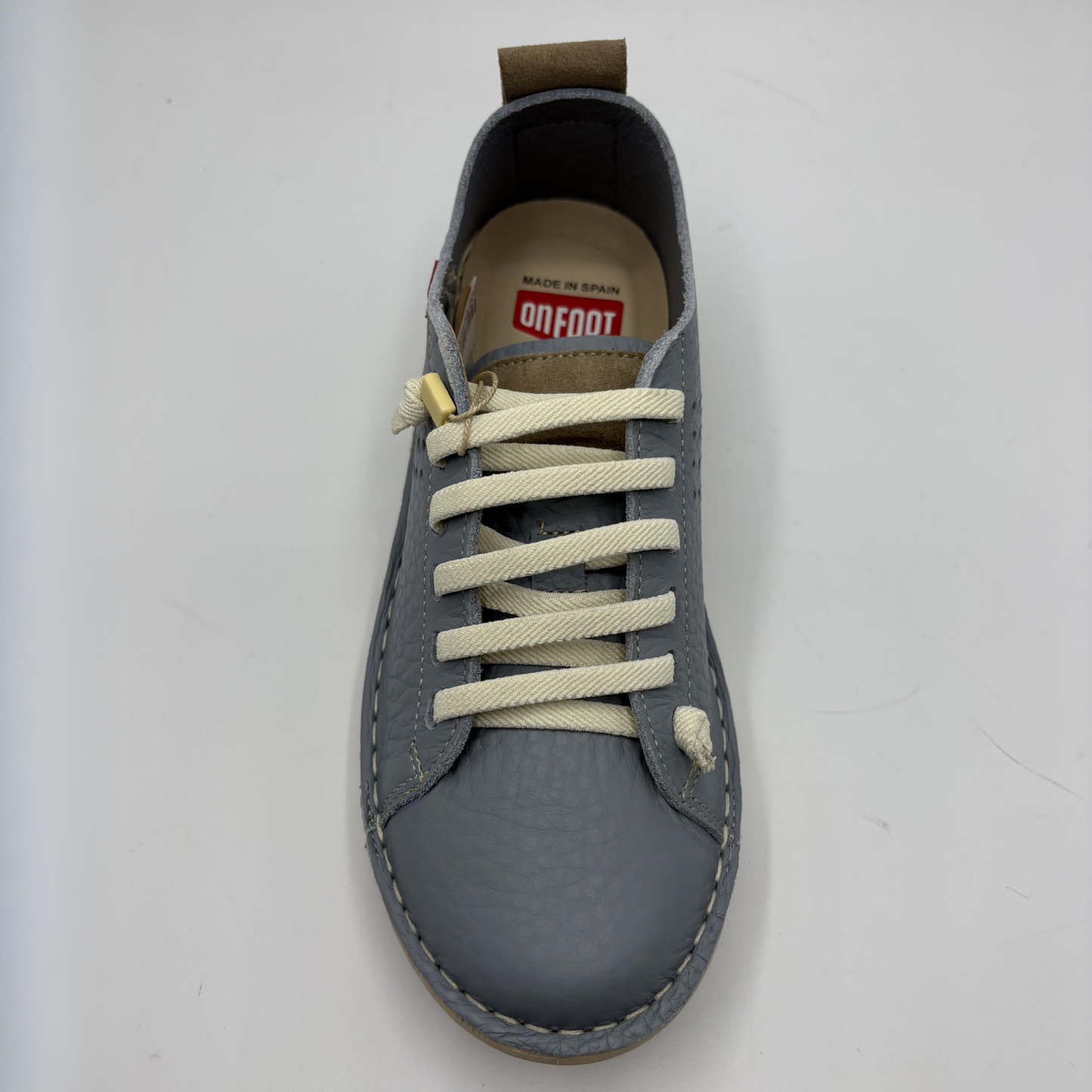 Gray sneaker with white laces on a light gray background