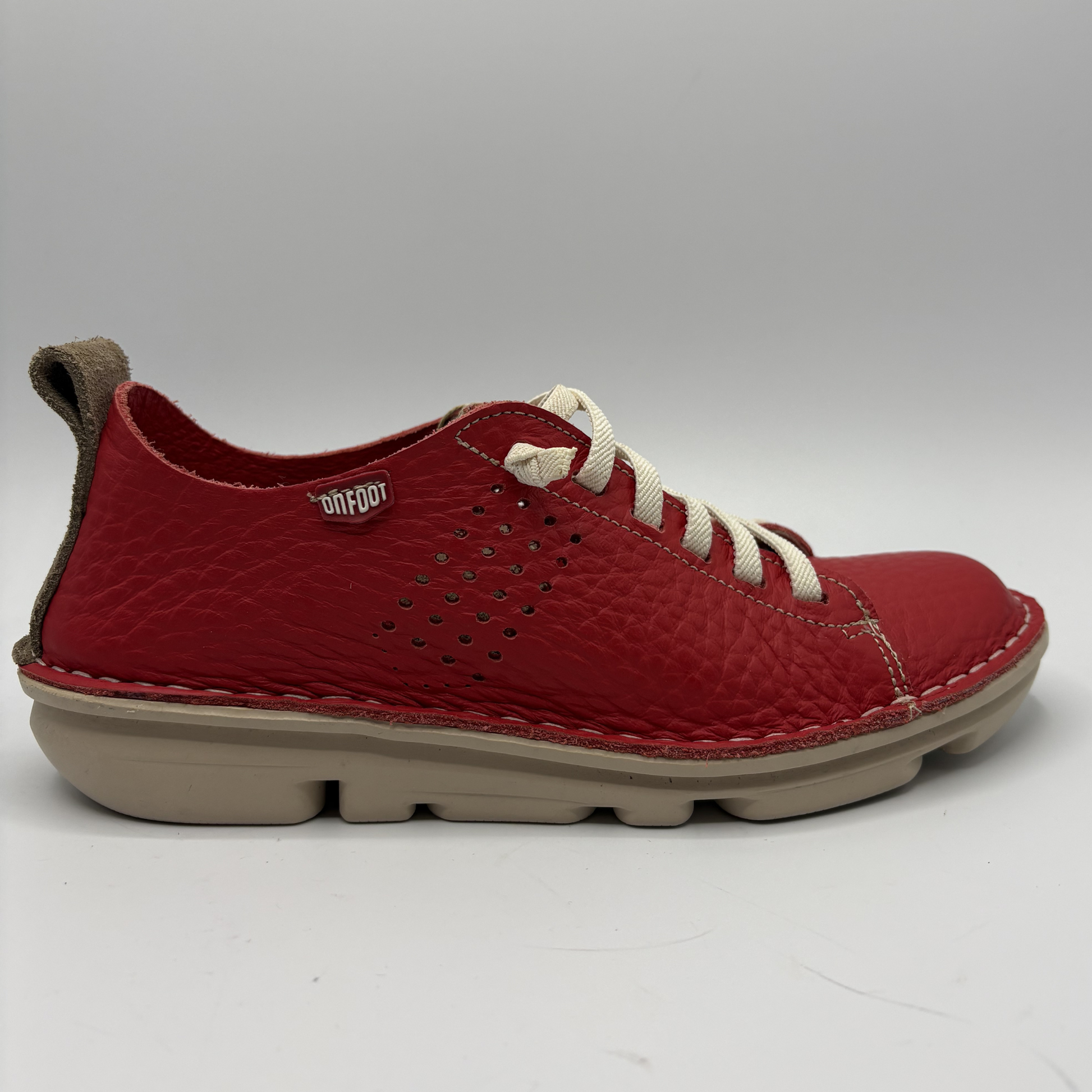 Right facing view of a red sneaker with white laces