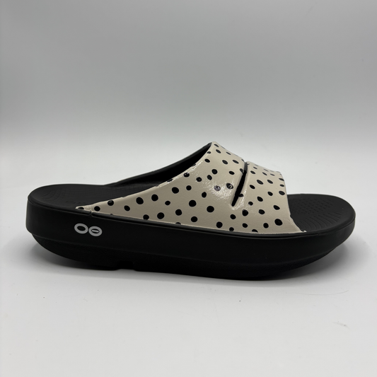View of a cream coloured slide sandal with a black outsole
