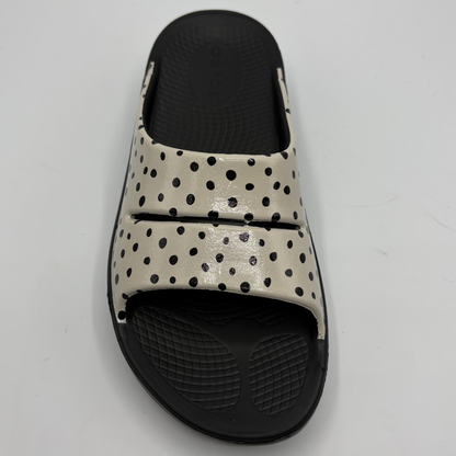 Black and beige polka dot slide sandal on a light gray background
