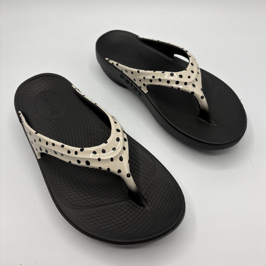 Black and beige flip-flops on a white background