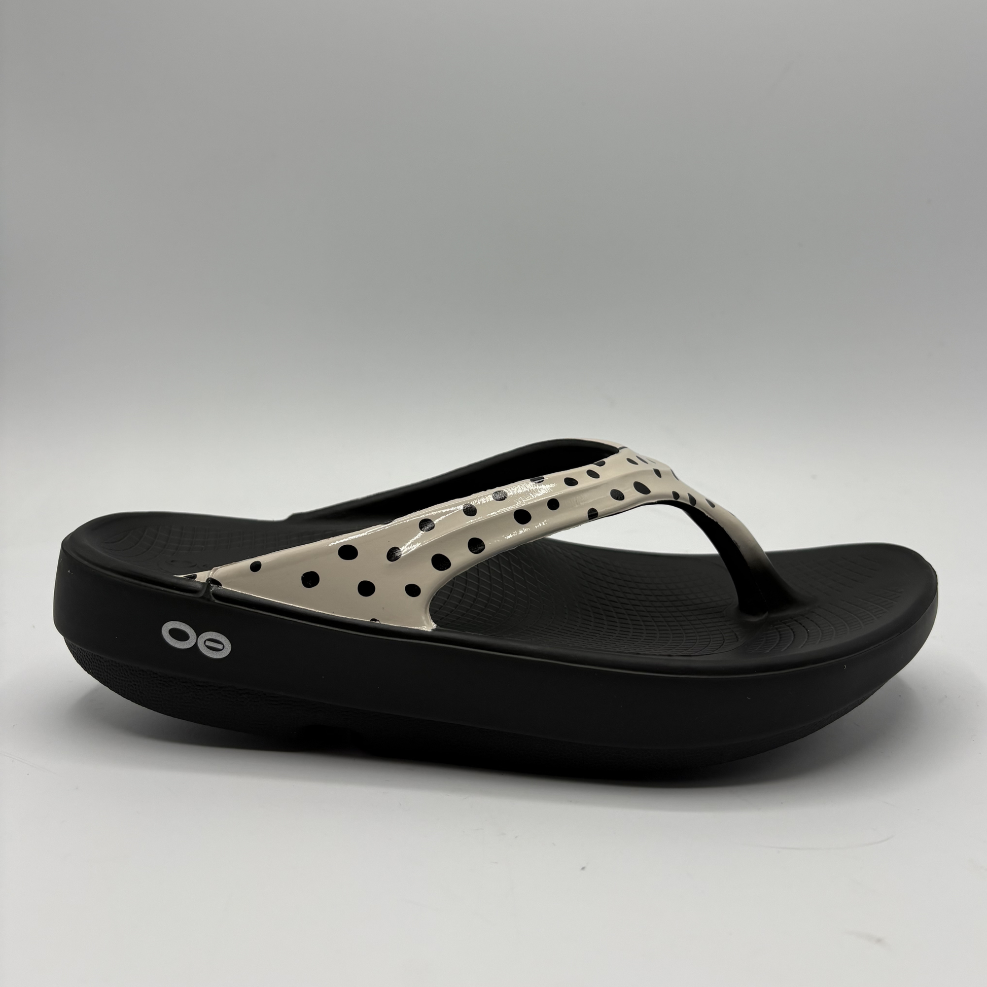 Black and beige sandal on a gray background