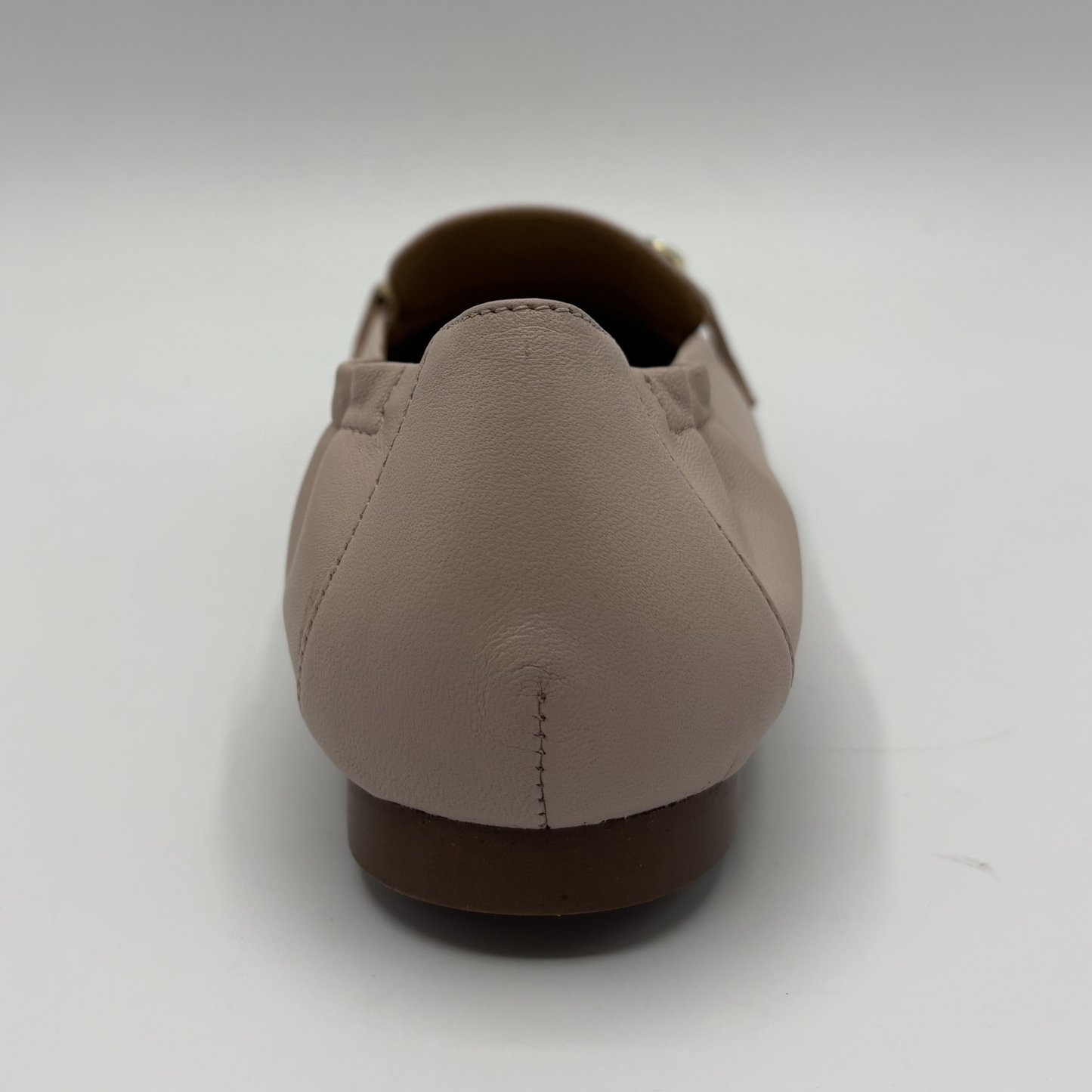 Back view of a leather loafer with a gold accent